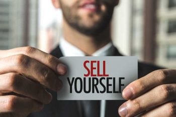 businessman holding sell yourself card